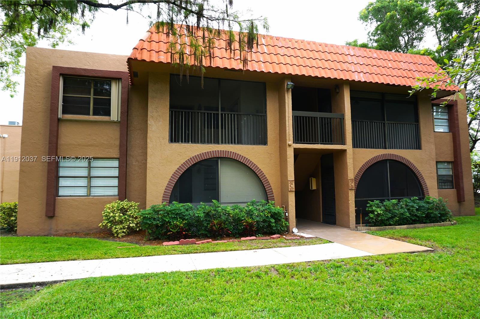 8632 Northwest 34th Place, Unit C207 Sunrise, FL 33351 - Photo 1 of 19 a front view of a house with garden