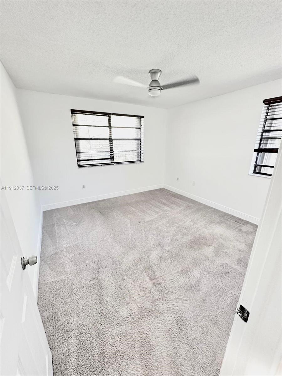 8632 Northwest 34th Place, Unit C207 Sunrise, FL 33351 - Photo 11 of 19 an empty room with windows and fan