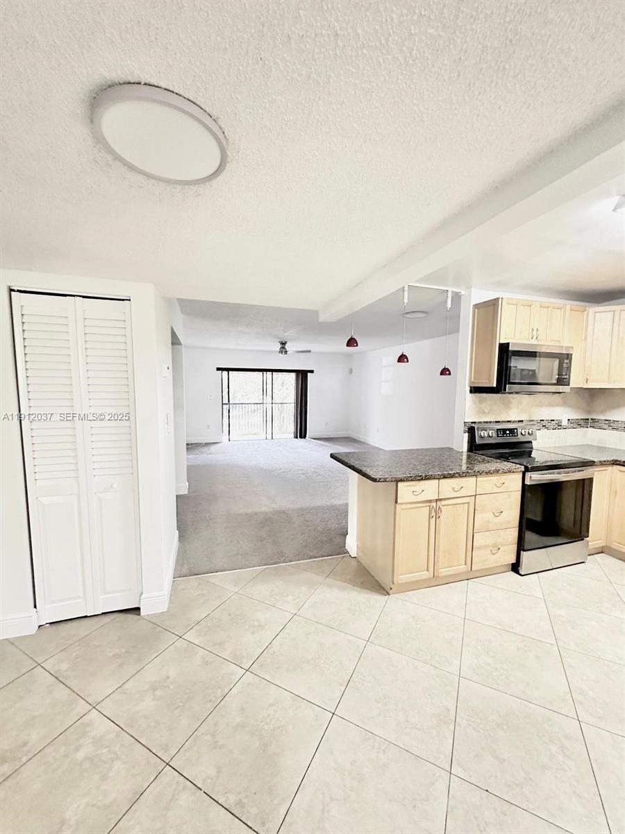 8632 Northwest 34th Place, Unit C207 Sunrise, FL 33351 - Photo 3 of 19 a kitchen with stainless steel appliances granite countertop a stove a sink and a refrigerator