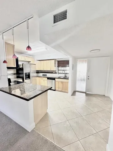 a kitchen with stainless steel appliances granite countertop a sink and cabinets