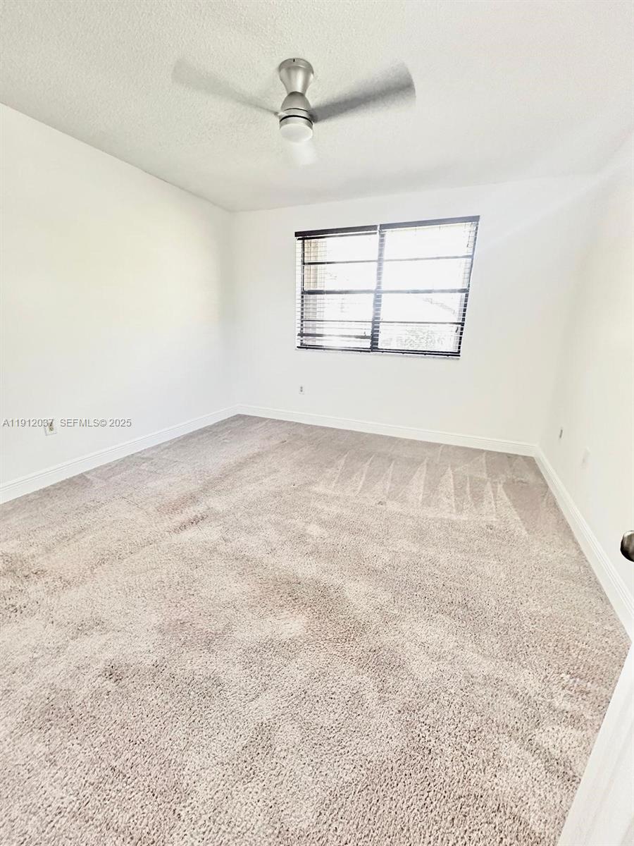8632 Northwest 34th Place, Unit C207 Sunrise, FL 33351 - Photo 10 of 19 an empty room with windows and ceiling fan