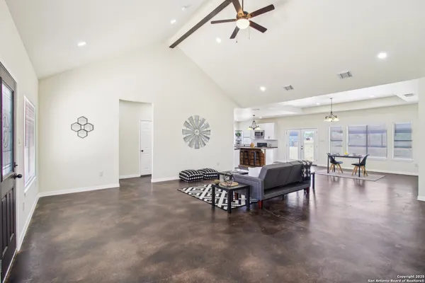 a living room with furniture a flat screen tv and a window