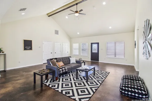 a living room with furniture and a ceiling fan