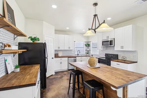 a kitchen with a stove a refrigerator and wooden cabinets
