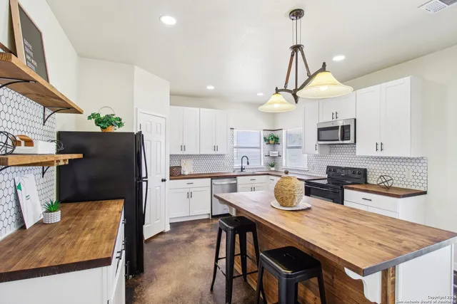 a kitchen with a stove a refrigerator and wooden cabinets