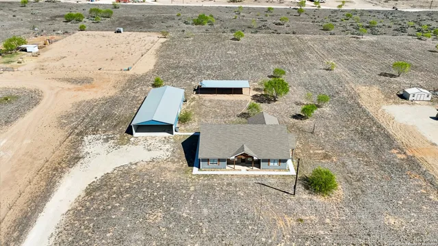 an aerial view of a house with a yard and lake view