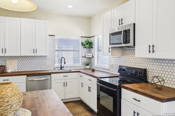 a kitchen with stainless steel appliances granite countertop a stove a kitchen island a table and chairs in it