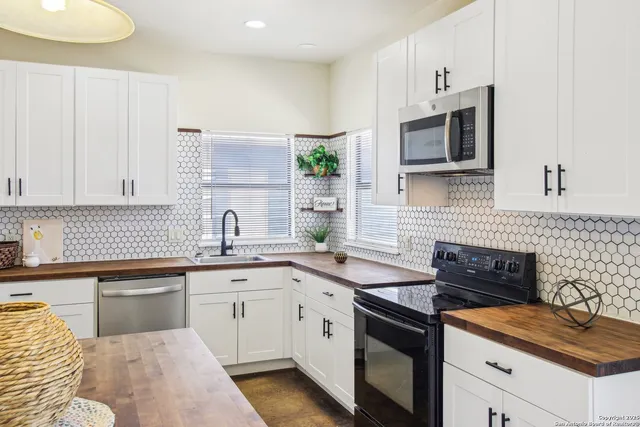 a kitchen with stainless steel appliances granite countertop a stove a kitchen island a table and chairs in it