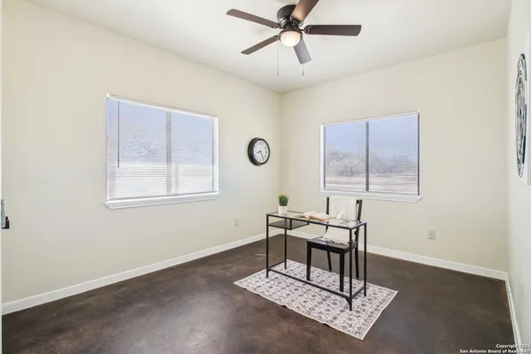 an empty room with chandelier fan