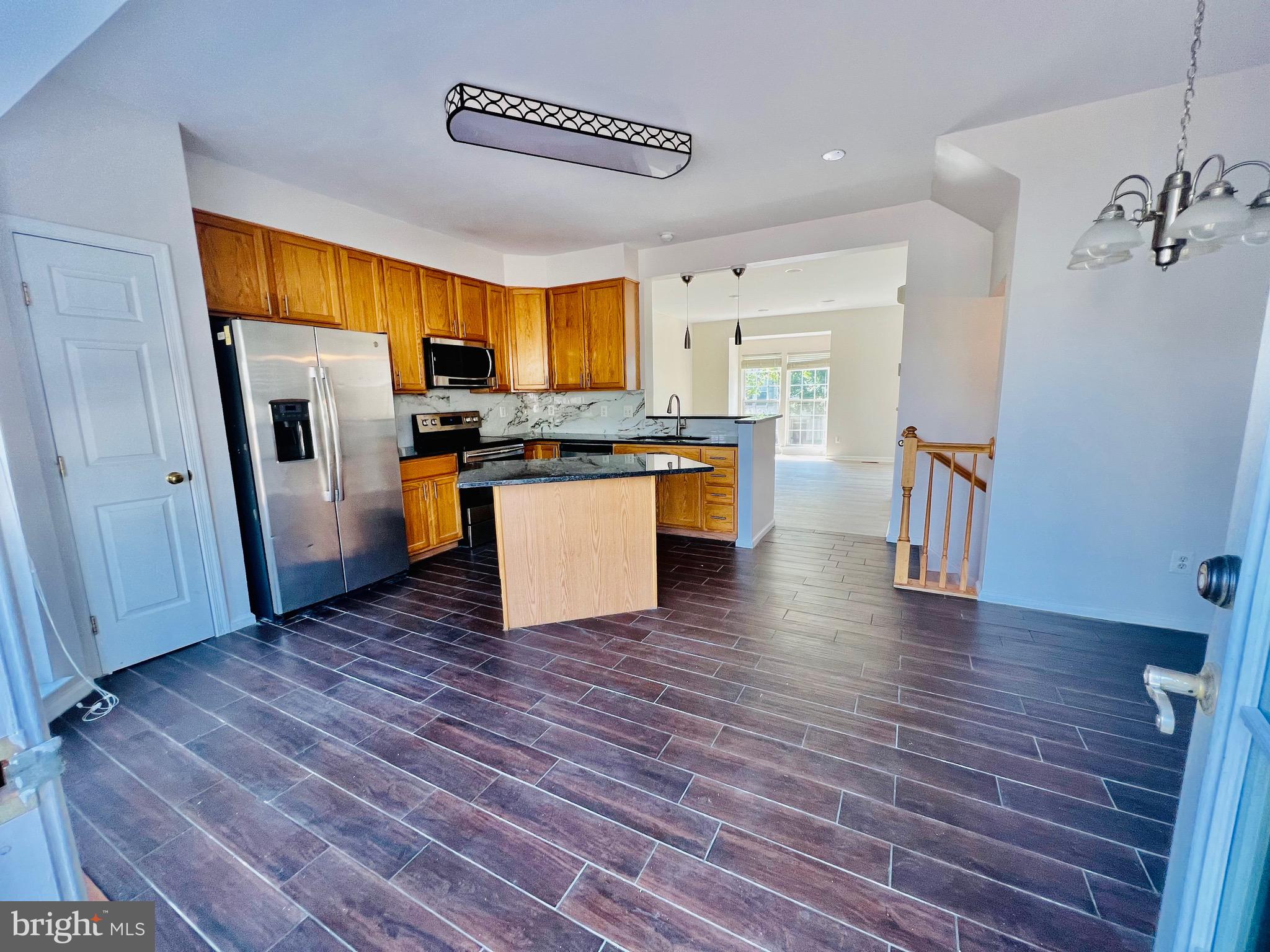 13251 Revillo Loop Woodbridge, VA 22191 - Photo 14 of 32 a view of a kitchen with a sink refrigerator and wooden floor
