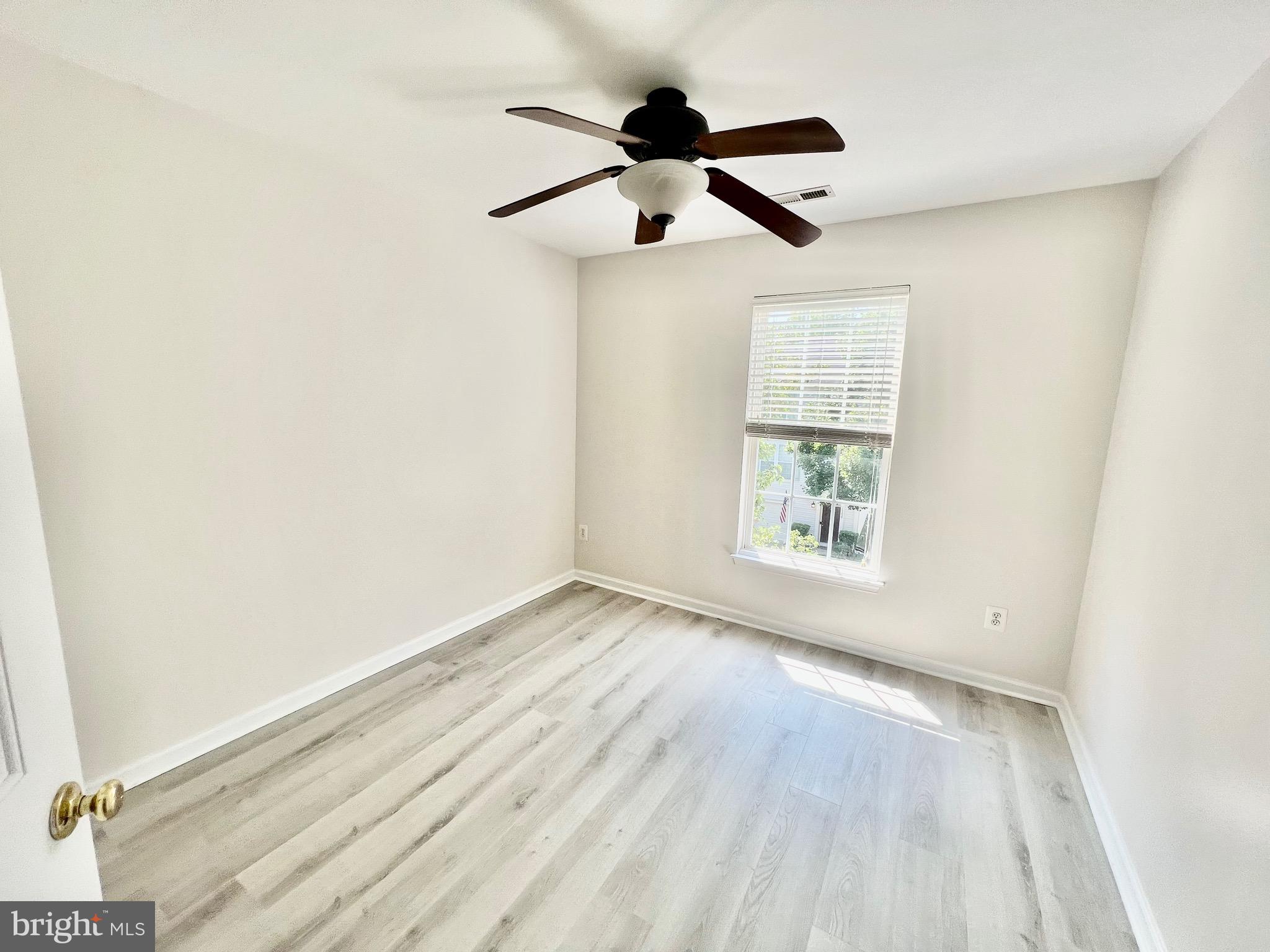 13251 Revillo Loop Woodbridge, VA 22191 - Photo 24 of 32 an empty room with wooden floor ceiling fan and windows