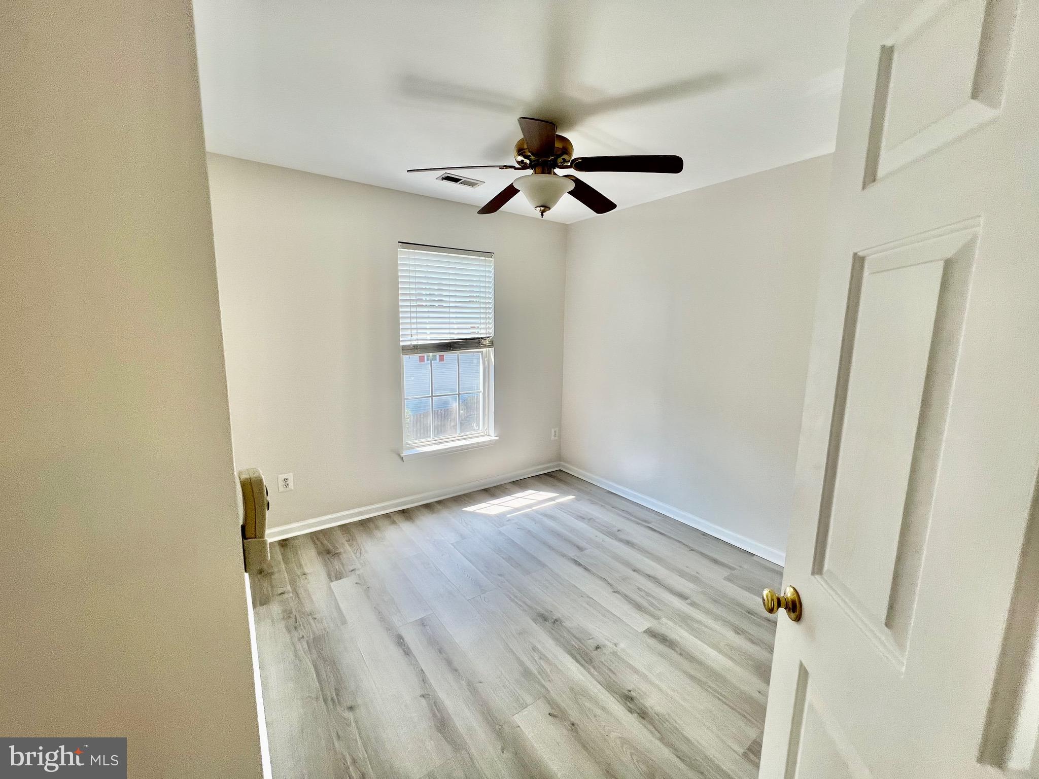 13251 Revillo Loop Woodbridge, VA 22191 - Photo 29 of 32 an empty room with wooden floor closet and windows
