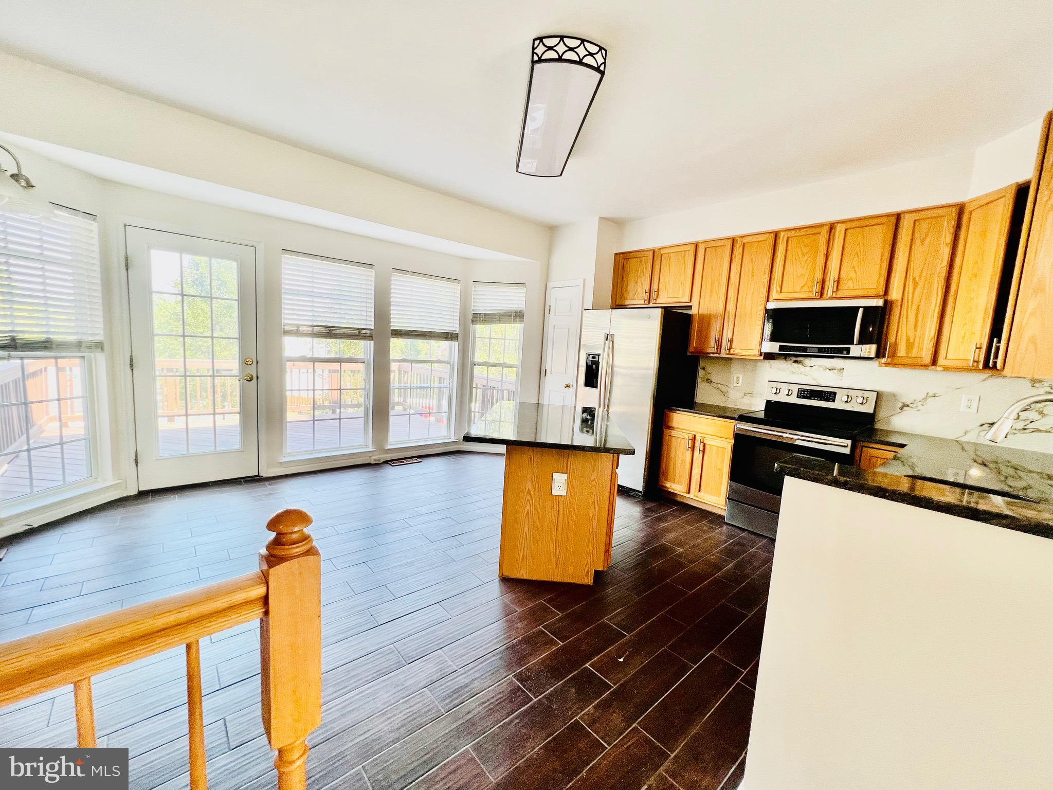 13251 Revillo Loop Woodbridge, VA 22191 - Photo 32 of 32 a kitchen with stainless steel appliances a stove a sink dishwasher a microwave oven with a dining table and wooden floor
