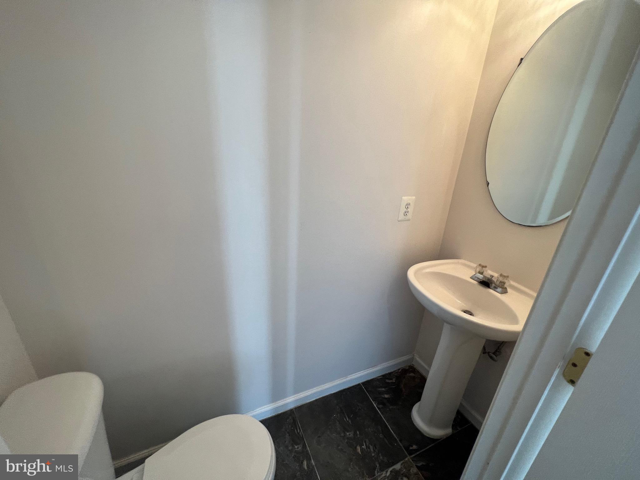 13251 Revillo Loop Woodbridge, VA 22191 - Photo 6 of 32 a bathroom with a toilet a sink and a mirror