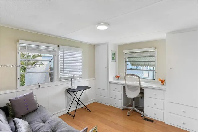 a view of a workspace with furniture and a window
