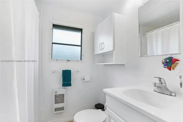 a bathroom with a sink toilet and mirror