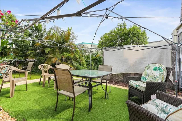 a backyard of a house with table and chairs