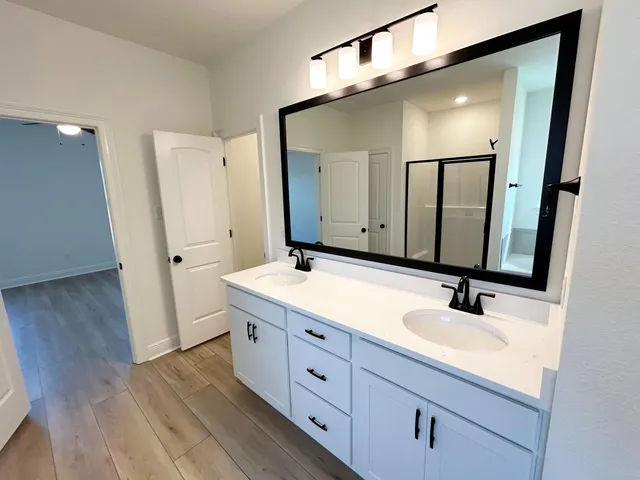 a bathroom with a double vanity sink and mirror