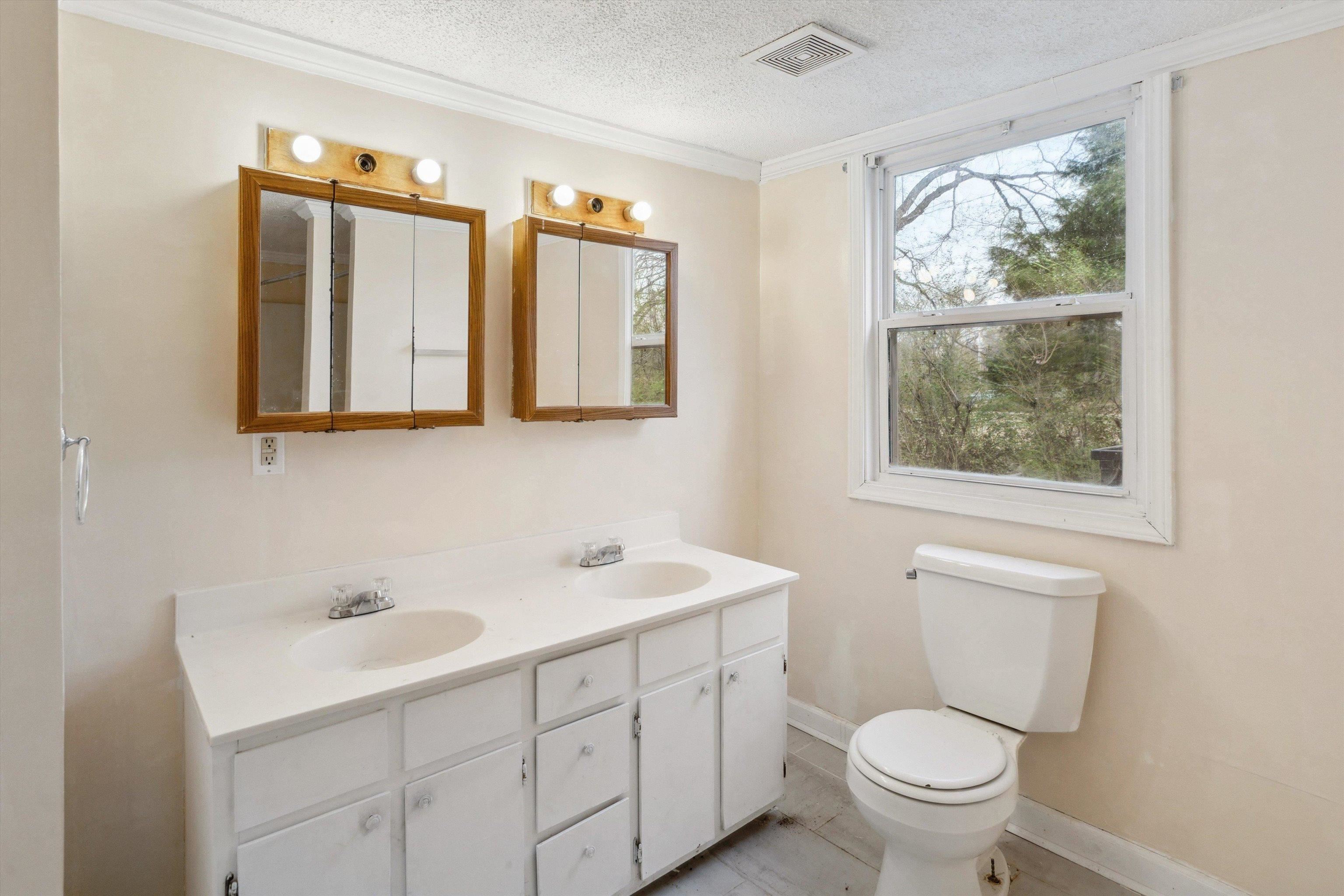 8457 East Kerrville Rosemark Road Millington, TN 38053 - Photo 14 of 32 Full bath with double vanity, a textured ceiling, and ornamental molding