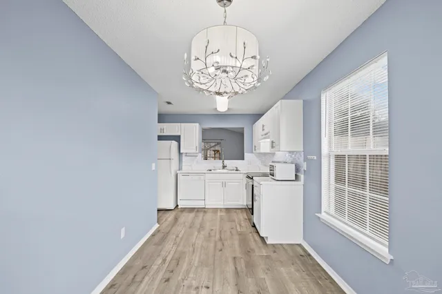a kitchen with a wooden floor window and stainless steel appliances