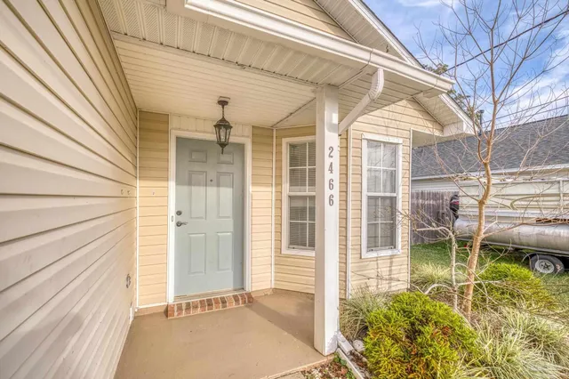 a view of a porch with a table and chairs and floor to ceiling window