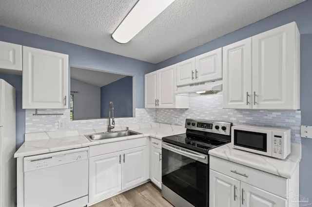 a kitchen with cabinets stainless steel appliances and a counter space