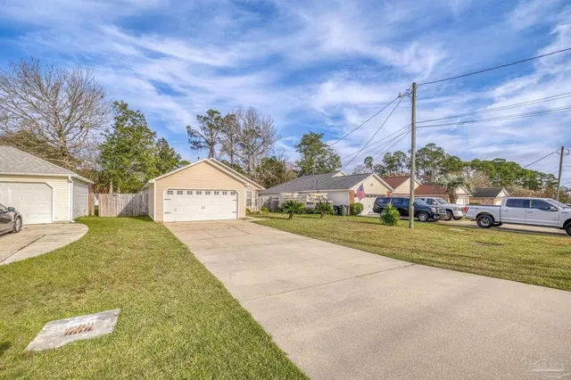 a view of a house with a yard and large tree