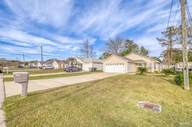 a view of a white house with a yard and potted plants
