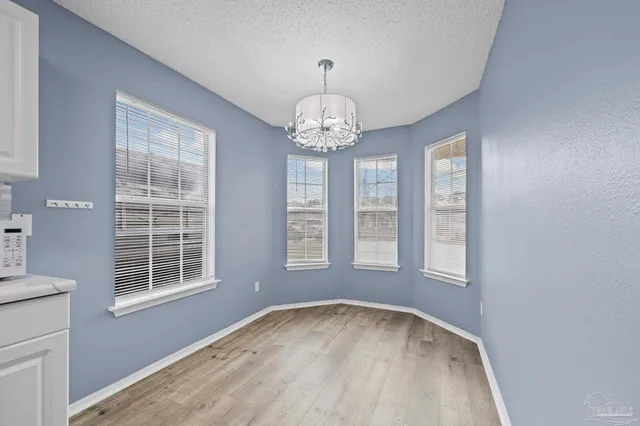 an empty room with windows and chandelier