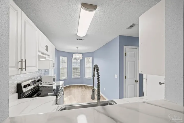 a room with stainless steel appliances lots of counter space and a sink