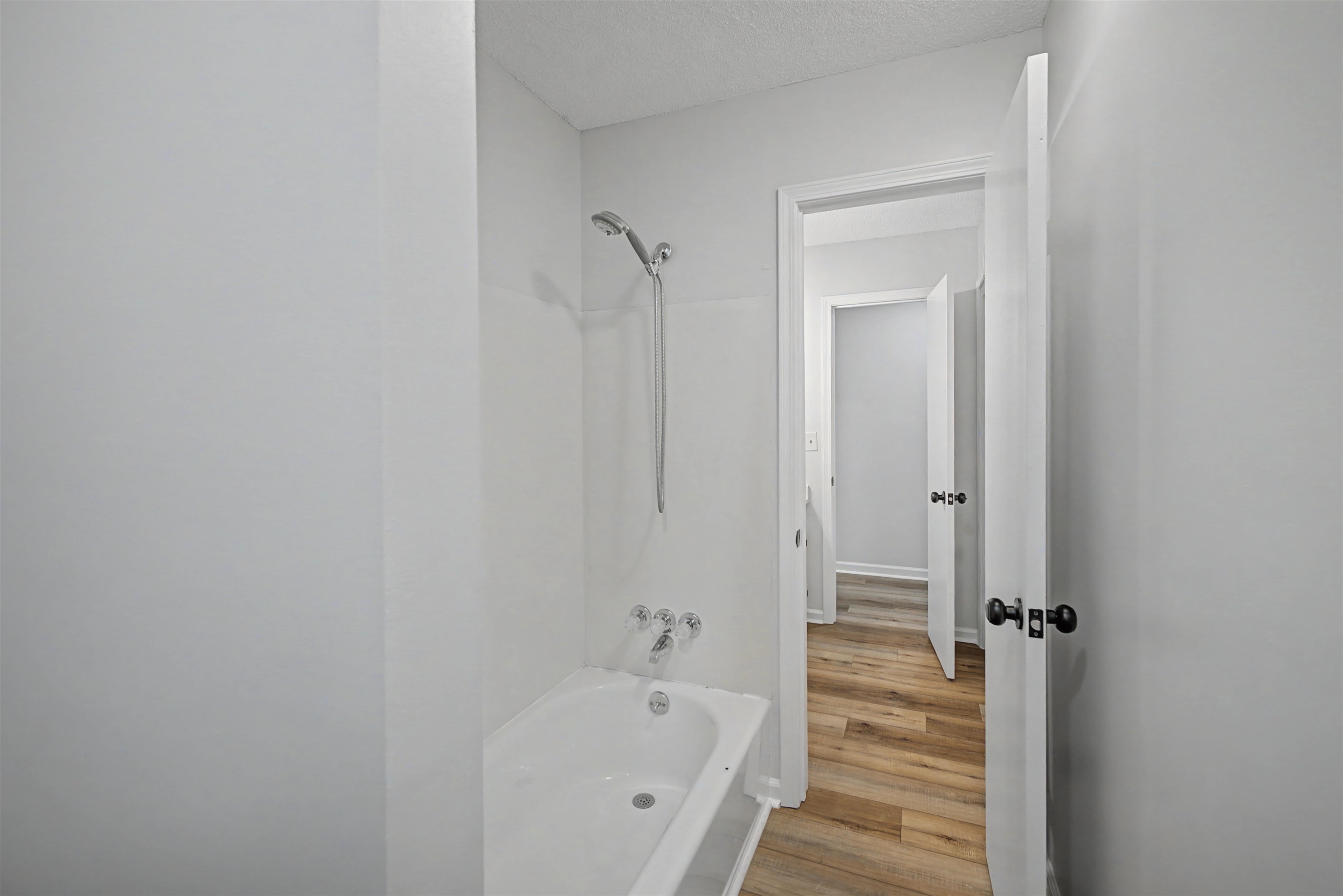 632 Cullum Road Munford, TN 38058 - Photo 32 of 38 Full bath with washtub / shower combination, light wood-type flooring, and a textured ceiling