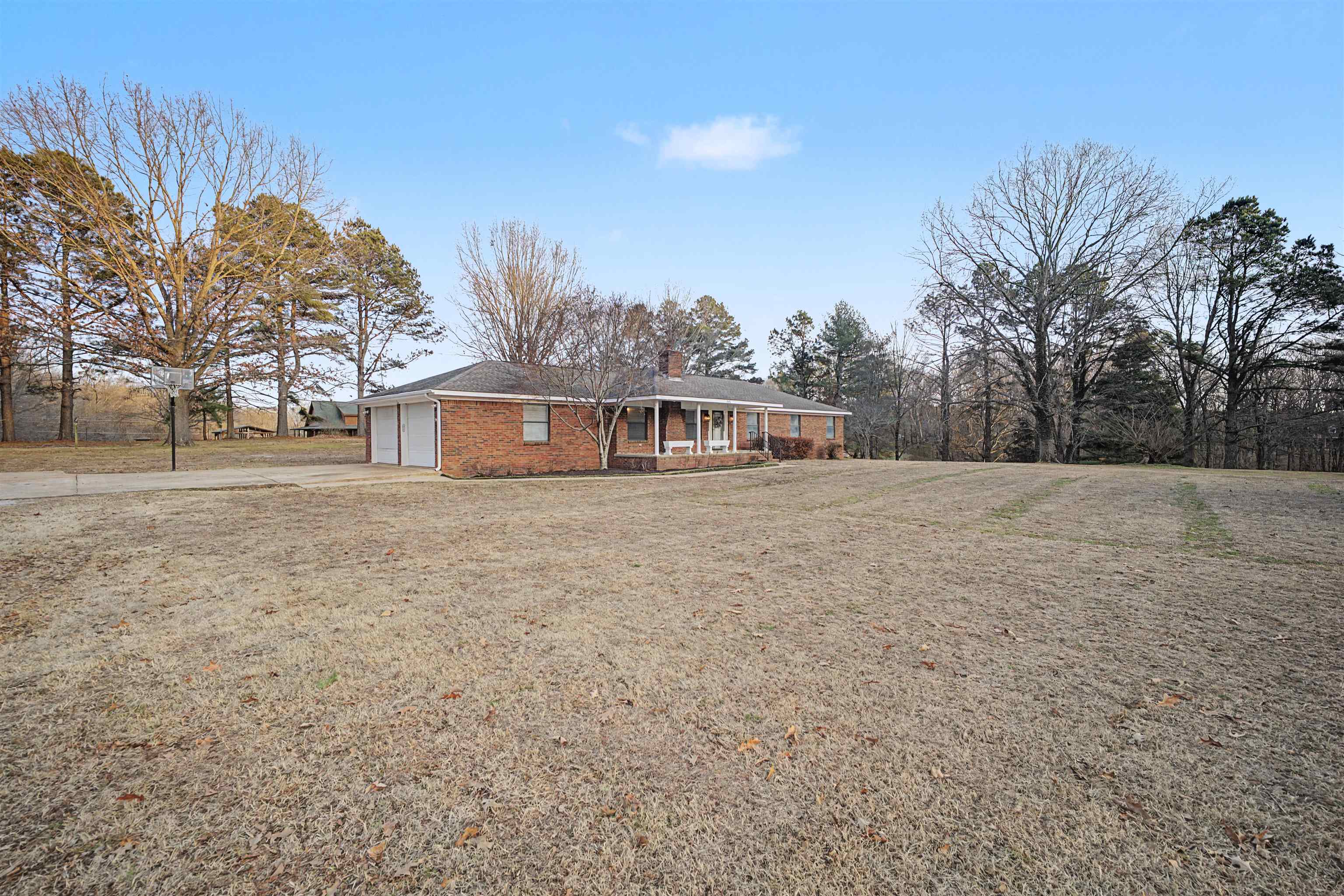 632 Cullum Road Munford, TN 38058 - Photo 34 of 38 View of front facade featuring a porch, driveway, a chimney, a front yard, and an attached garage