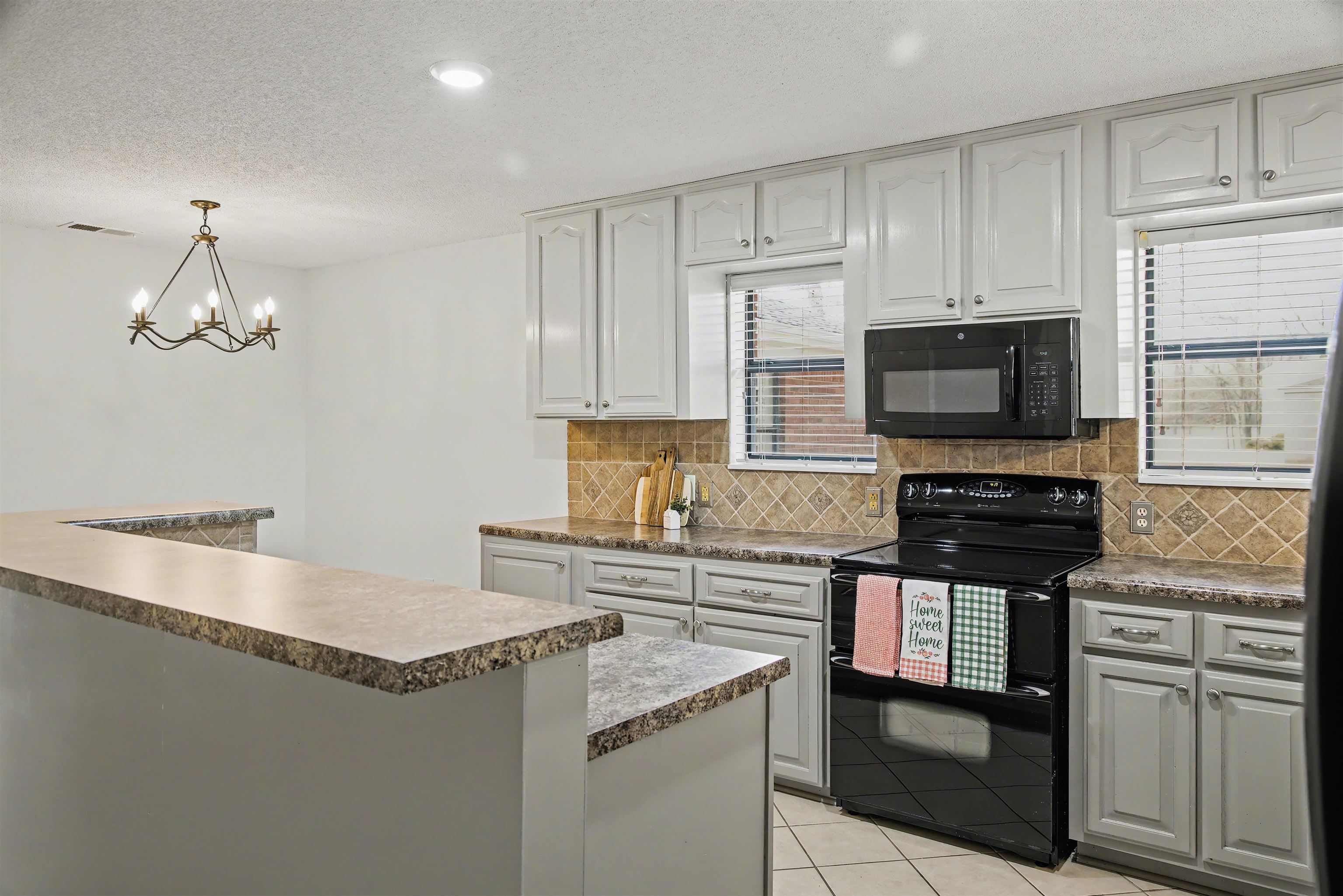 632 Cullum Road Munford, TN 38058 - Photo 9 of 38 Kitchen featuring black appliances, light tile patterned floors, dark countertops, tasteful backsplash, and a textured ceiling