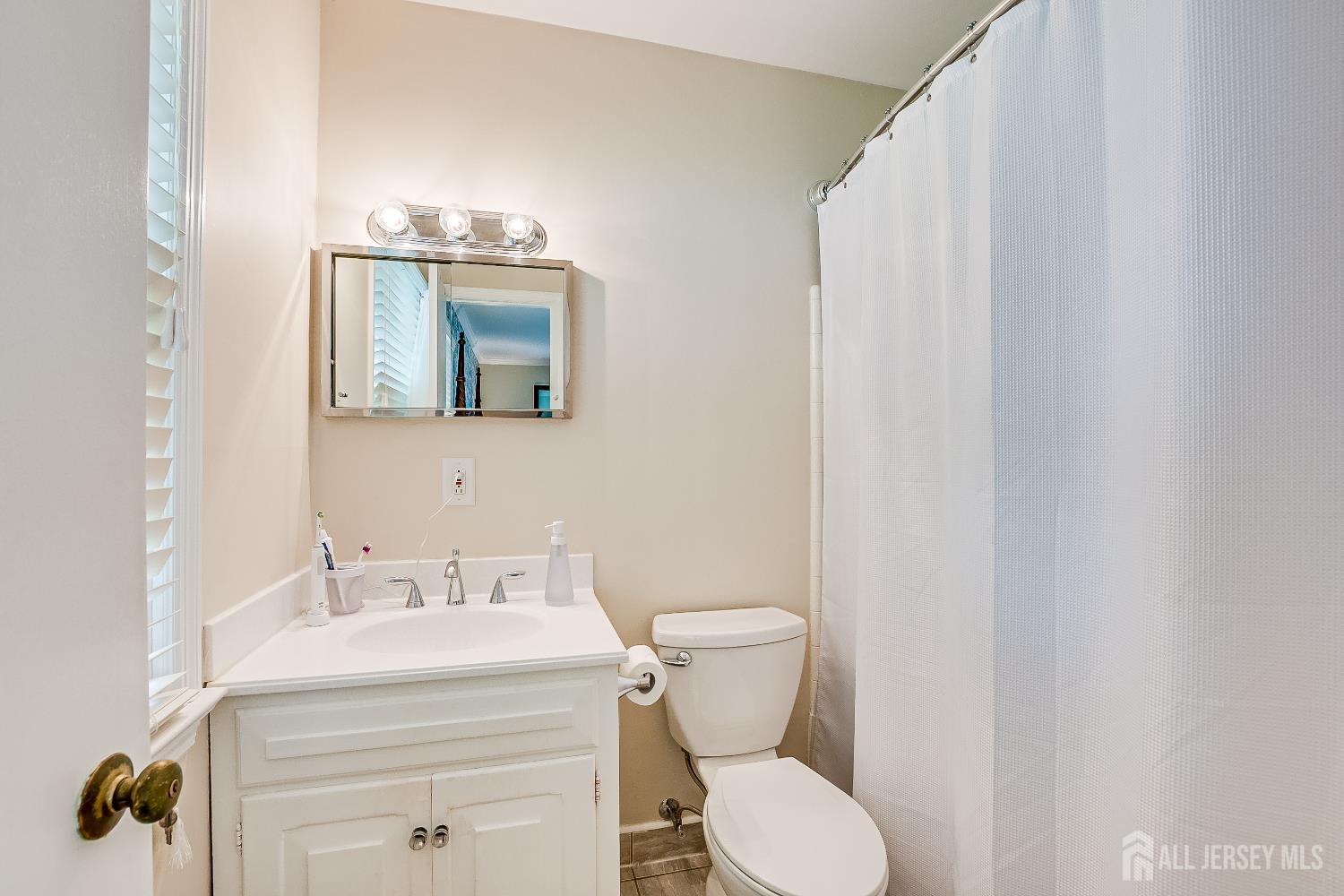 240 Dwight Road Middletown, NJ 07748 - Photo 16 of 28 a bathroom with a sink toilet and mirror