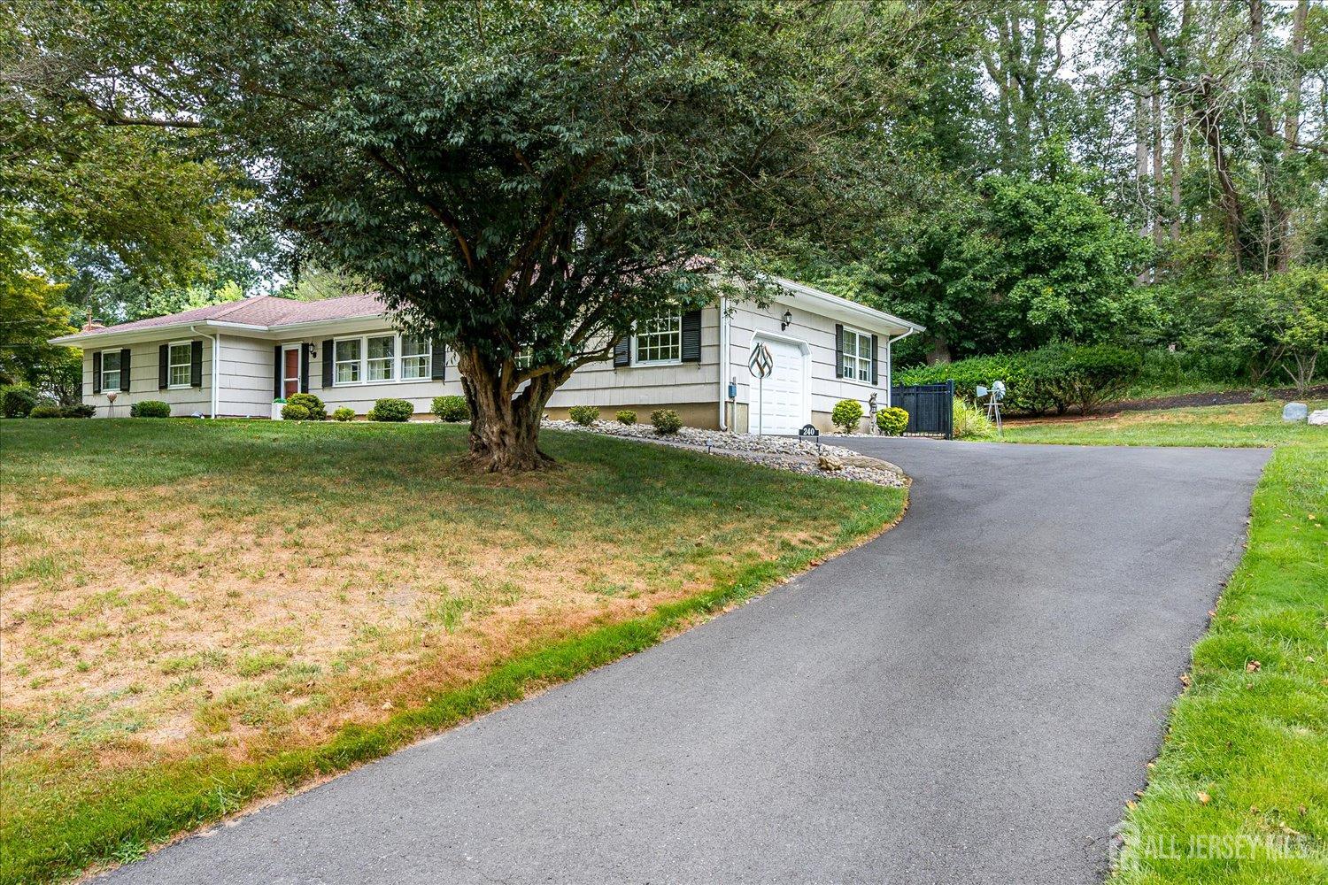 240 Dwight Road Middletown, NJ 07748 - Photo 8 of 28 a front view of a house with a garden and tree