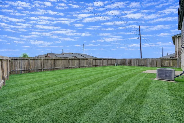 a view of yard with swimming pool and wooden fence