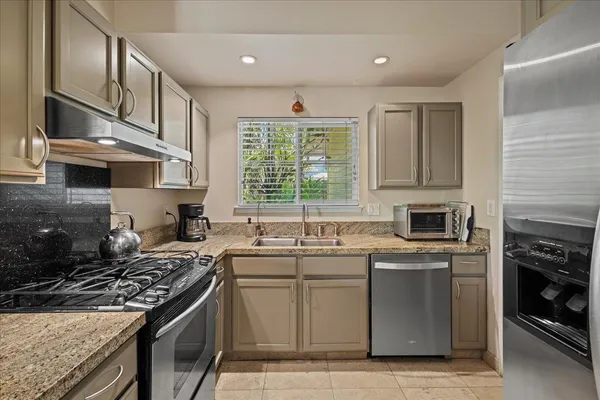 a kitchen with a sink stove top oven and cabinets