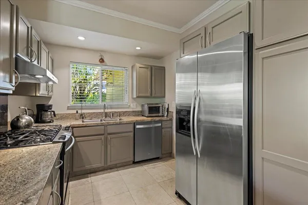 a kitchen with stainless steel appliances granite countertop a refrigerator a sink a stove and washer