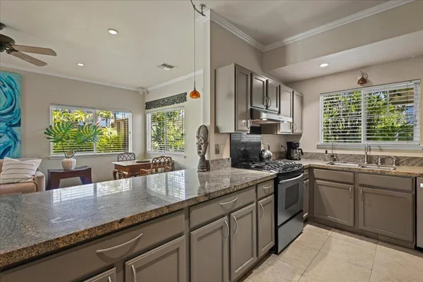 a kitchen with lots of counter top space a sink and large window