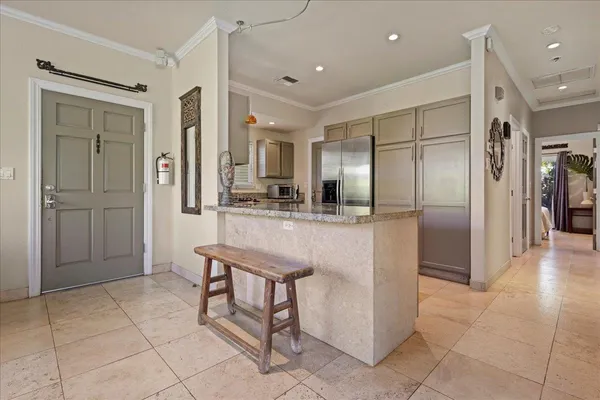 a kitchen with stainless steel appliances kitchen island granite countertop a refrigerator and a sink