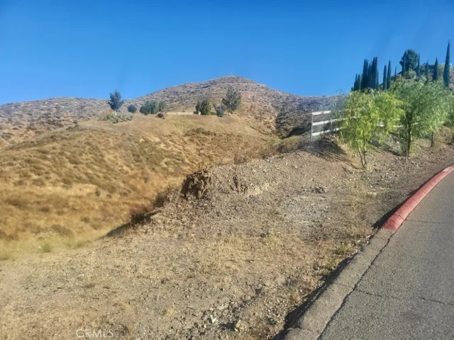 a view of a dry yard with mountains in the background