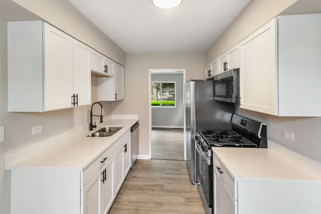a kitchen with a sink a stove and cabinets
