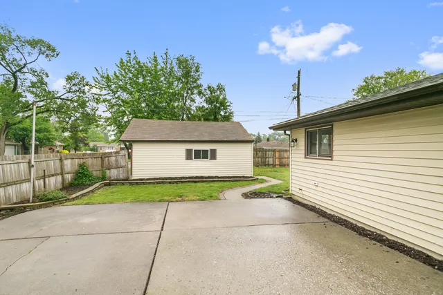 a view of a house with a yard and large tree