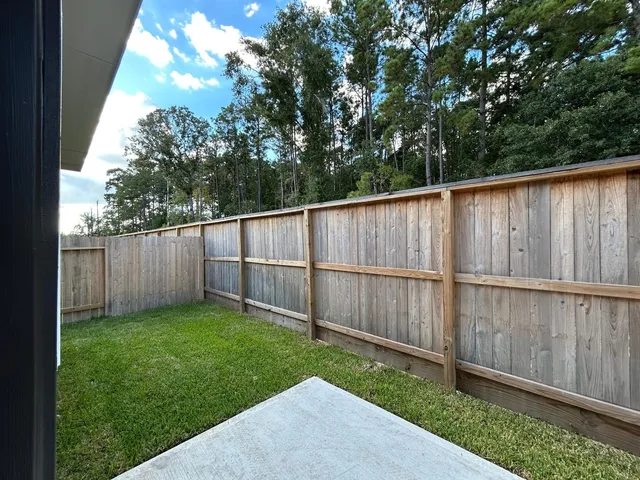 a view of a backyard with a trees and wooden fence