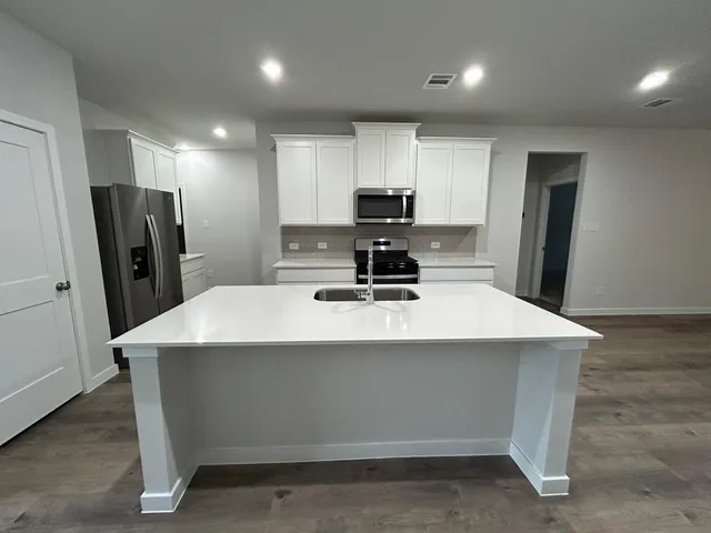 a kitchen with stainless steel appliances a refrigerator sink and microwave