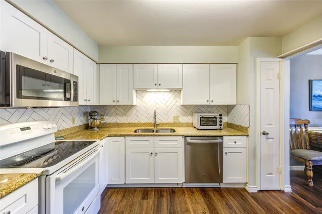 a kitchen with stainless steel appliances granite countertop a sink and cabinets