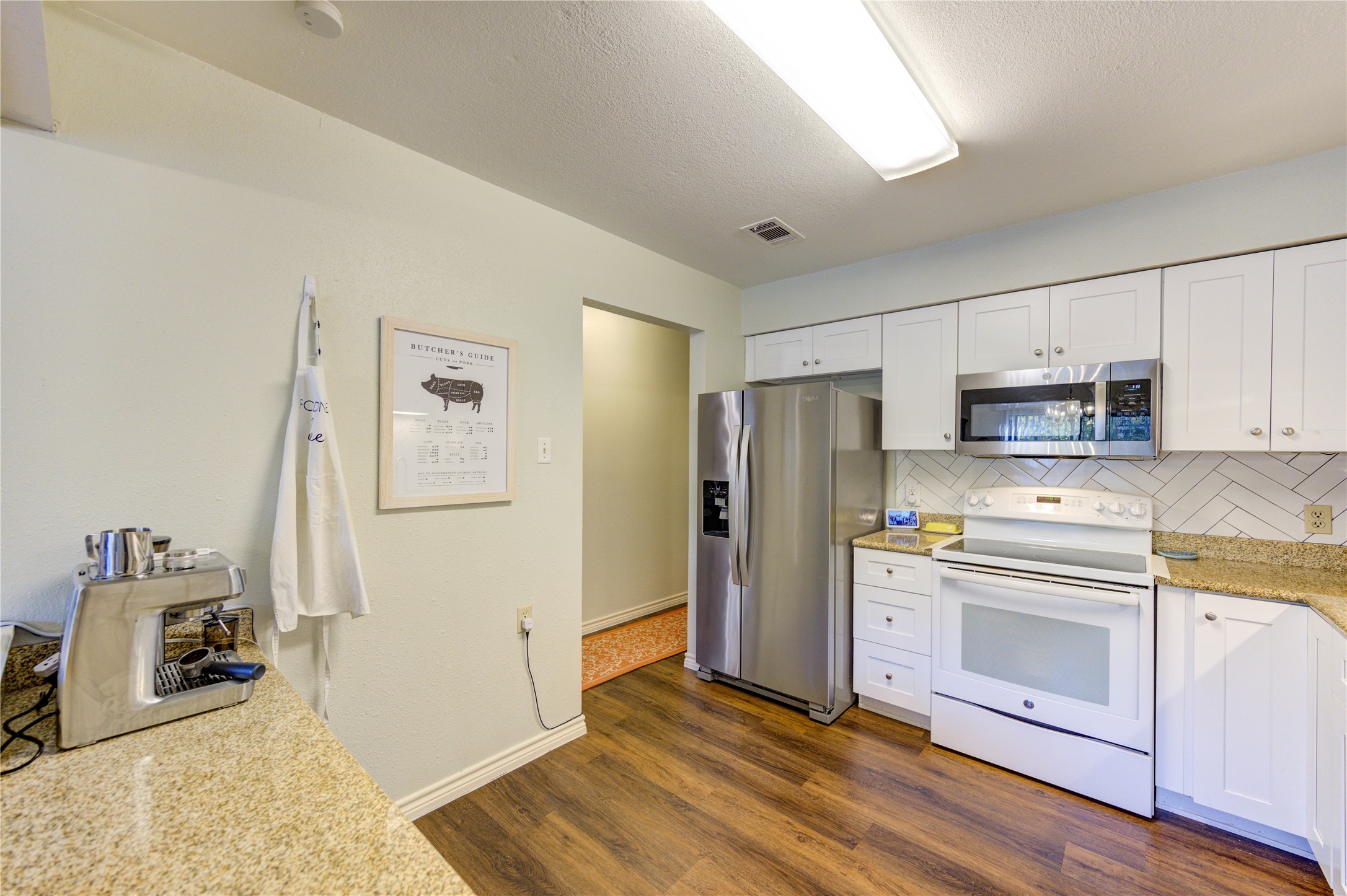 7861 Champion Pines Drive Spring, TX 77379 - Photo 12 of 34 a kitchen with stainless steel appliances a stove a refrigerator and white cabinets