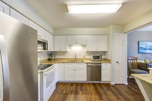 a kitchen with stainless steel appliances granite countertop a stove a sink and a refrigerator