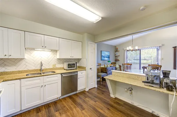 a kitchen with sink a microwave and cabinets