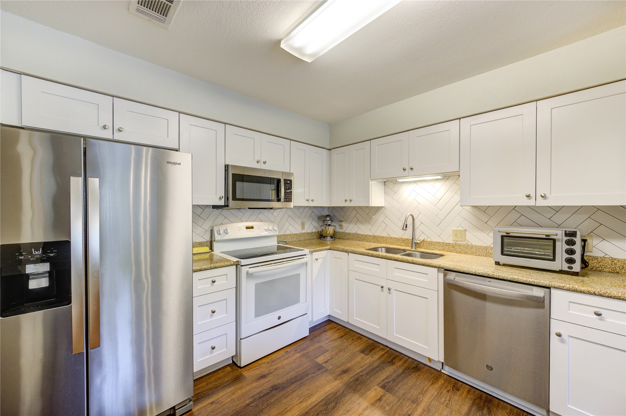 7861 Champion Pines Drive Spring, TX 77379 - Photo 15 of 34 a kitchen with stainless steel appliances a sink cabinets and a refrigerator